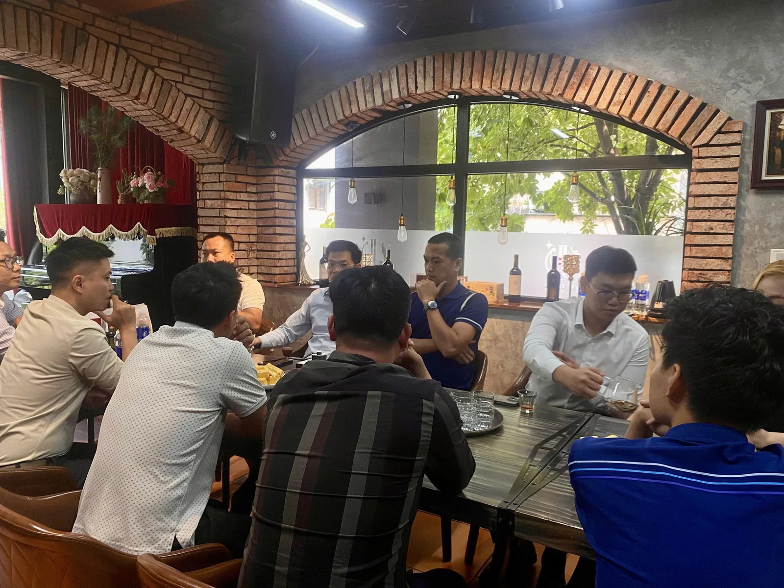 Thành viên CEO1987 lắng nghe trao đổi tại buổi họp định kỳ tháng 7, không gian ấm cúng bên ly rượu vang.