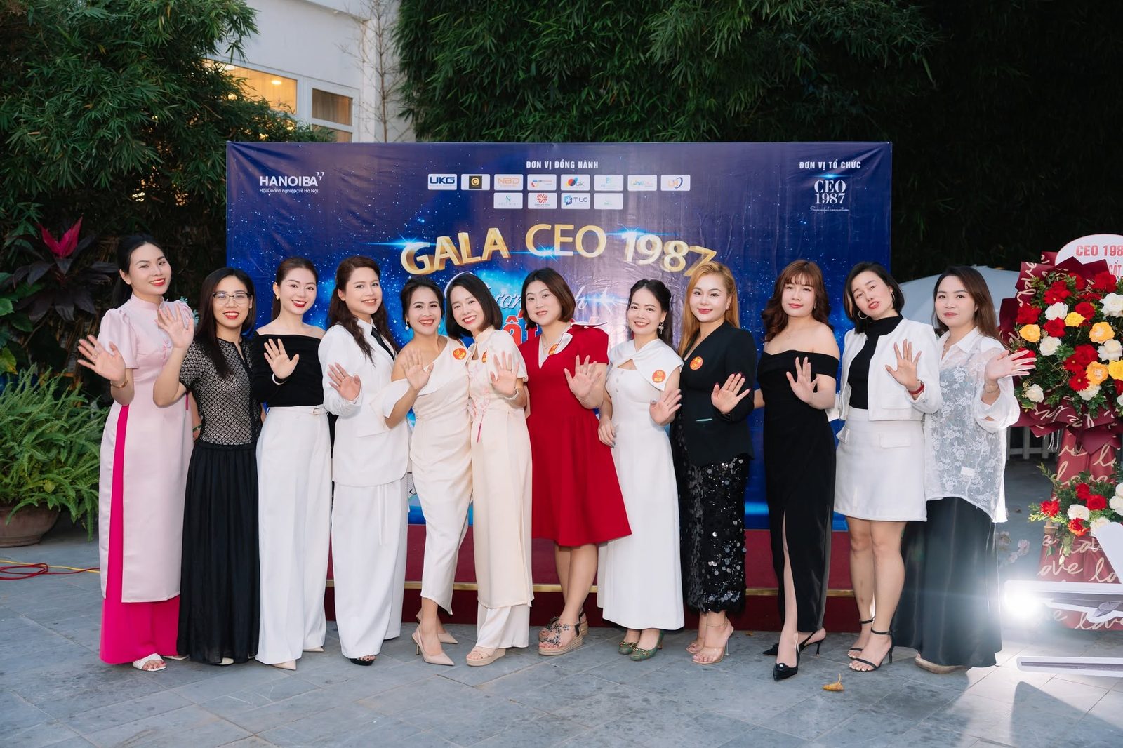 Các nữ doanh nhân CEO 1987 rạng rỡ vẫy tay trước backdrop sự kiện Gala Cất Cánh CEO 1987 cùng HANOIBA đồng hành