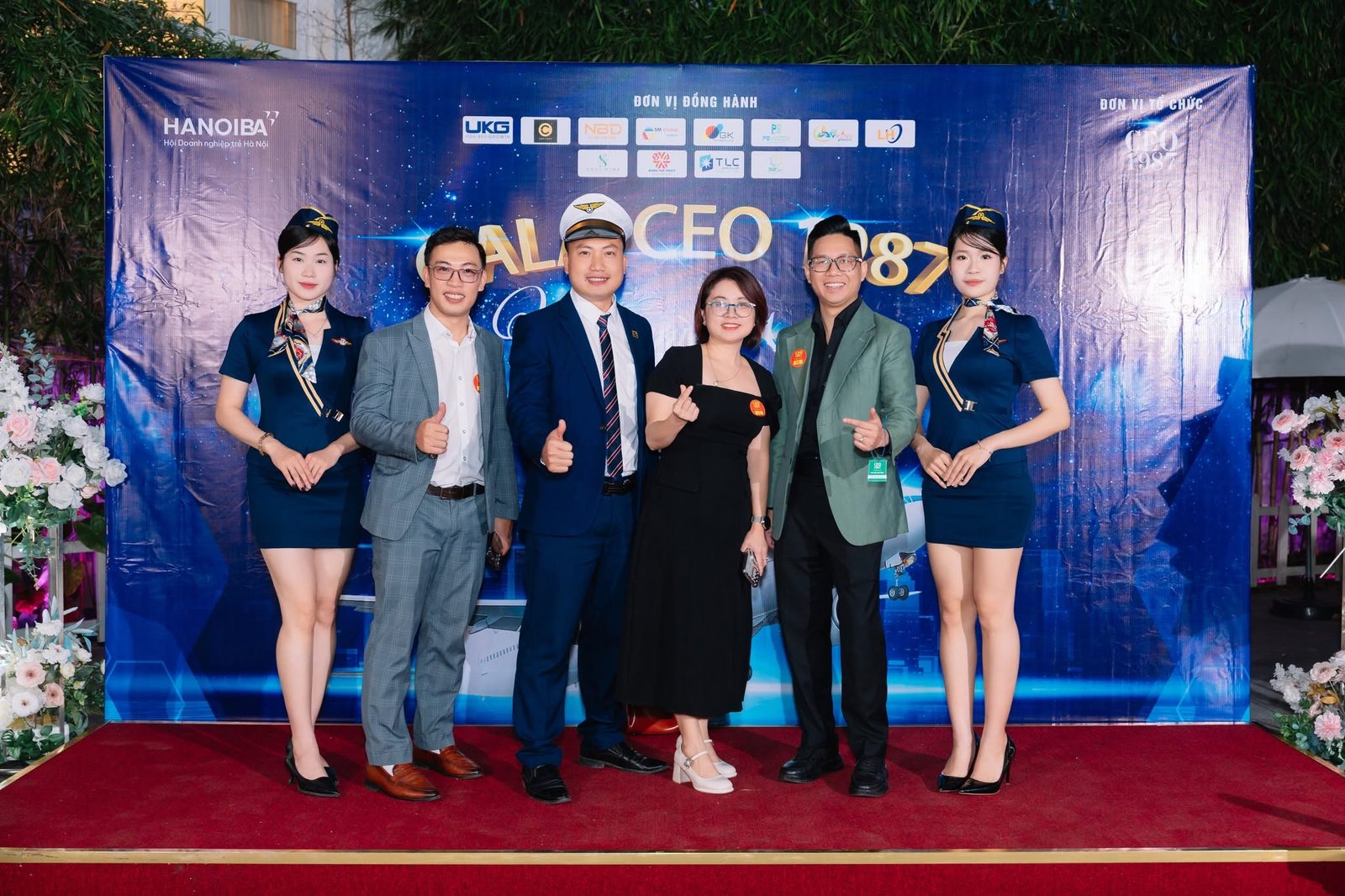 Thành viên CEO 1987 hào hứng check-in cùng đội hình tiếp viên hàng không và phi công tại backdrop Gala Cất Cánh