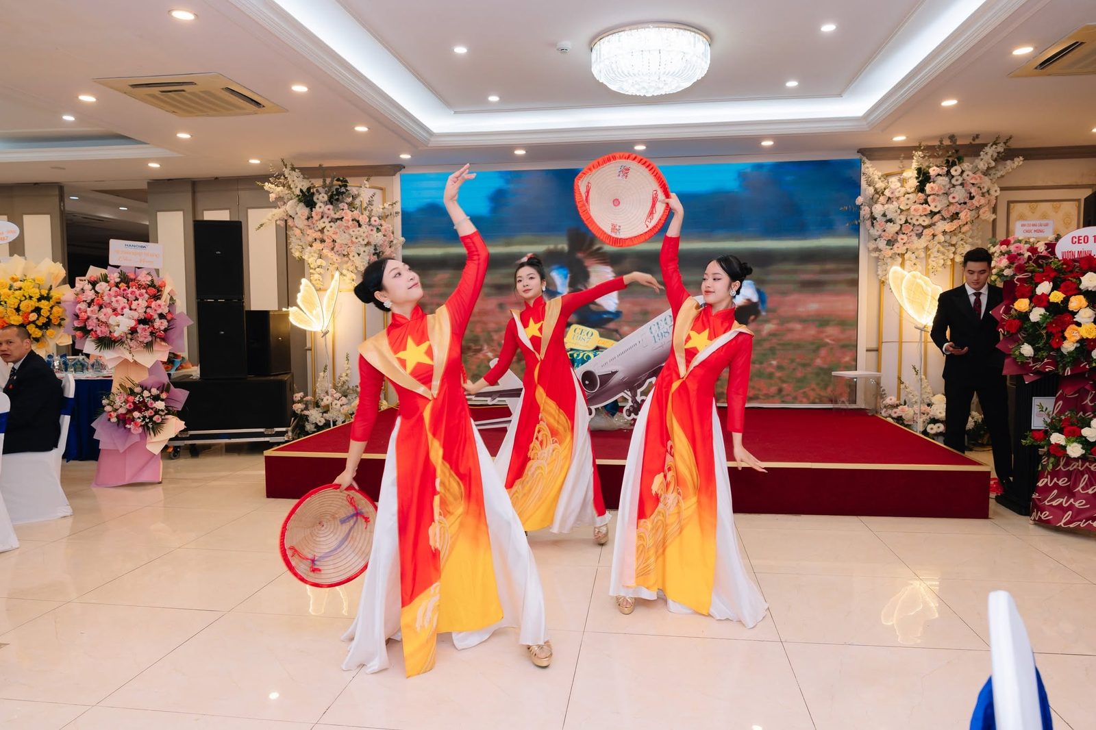 Nhóm vũ công áo dài đỏ vàng biểu diễn múa nón lá tại đêm gala Vươn Mình Cất Cánh của CEO 1987