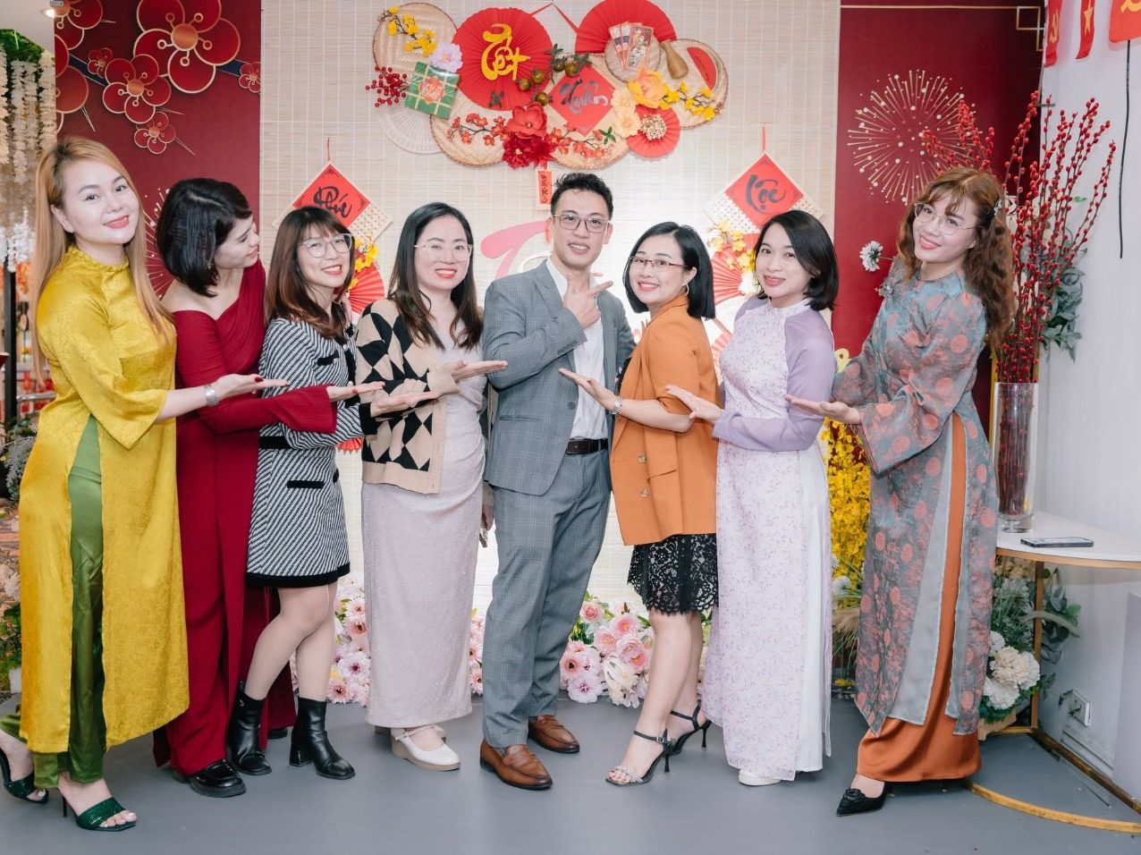 Các nữ doanh nhân CEO1987 tạo dáng vui tươi tại góc check-in Tết với phông nền hoa mai đỏ rực